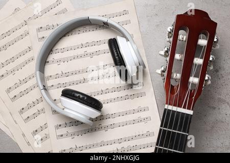 Komposition mit Gitarre und Notierung auf grauem Tisch, flach liegend Stockfoto