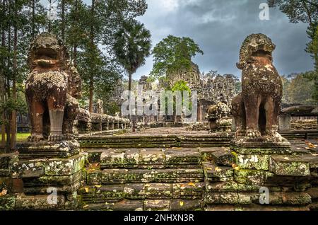 Riesige Löwen auf einer Steinplattform bewachen den Eingang zu den Ruinen des berühmten Bayon-Tempels in Angkor Thom und in der Nähe von Angkor Wat in Kambodscha. Stockfoto