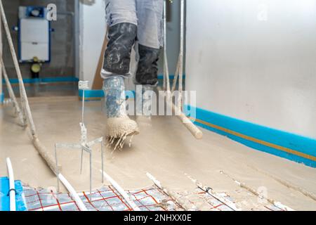 Aufbringung von Beton auf dem Boden bei Fußbodenheizungen Stockfoto