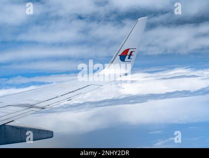 Kuala Lumpur, Malaysia - 22. Februar 2023: Flügel der malaysischen Fluggesellschaften im Flug. Malaysia Airlines ist die Flaggenfluggesellschaft Malaysias. Stockfoto