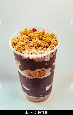 Cremige acai-Schüssel mit Müsli auf weißem Hintergrund Stockfoto