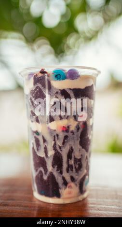 acai-Schüssel mit kondensierter Milch und bunten Schokoladenchips Stockfoto