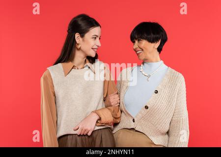 Glückliche asiatische Mutter und Tochter, die sich isoliert auf Korallen ansehen Stockfoto