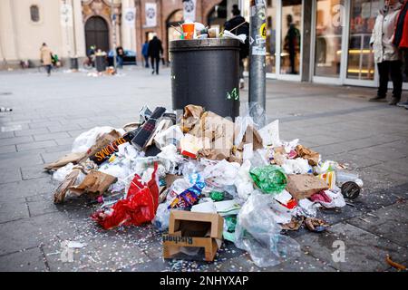 München, Deutschland. 22. Februar 2023. Am Marienplatz ist während eines zweitägigen Warnstreiks der Münchner Straßenreiniger ein überlaufender Mülleimer zu sehen. Aufgrund des Streiks der Münchner Straßenreiniger wurde Müll am Viktualienmarkt nach den Feierlichkeiten für den Shrove-Dienstag zurückgelassen. Kredit: Matthias Balk/dpa/Alamy Live News Stockfoto