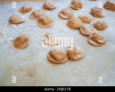 Nahaufnahme: Tortelli gefüllt mit Kürbis gefüllt mit hausgemachter Pasta, Oma kocht saisonale „Tortelli di zucca“, traditionelle italienische gefüllte Pas Stockfoto