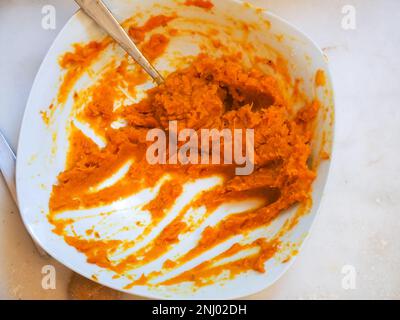 Seniorin bereitet gefüllte Kürbis-Ravioli-Tortelli mit italienischem Vollkornmehl zu Hause zu, hausgemachtes Essenskonzept Stockfoto