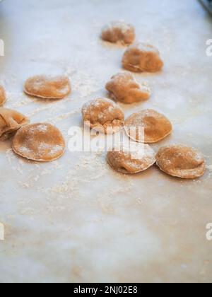 Nahaufnahme: Tortelli gefüllt mit Kürbis gefüllt mit hausgemachter Pasta, Oma kocht saisonale „Tortelli di zucca“, traditionelle italienische gefüllte Pas Stockfoto