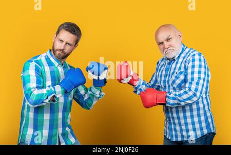 Bild einer Generation von Männern, die kämpfen, tragen Boxhandschuhe. Zwei Generationen Männer kämpfen Stockfoto