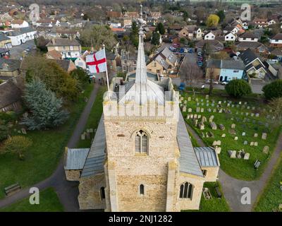 Luftaufnahme einer englischen Nationalflagge St. Georges, die auf dem Kirchturm des englischen Dorfes zu sehen ist. Das feine Bleidach auf dem Turm ist zu sehen. Stockfoto