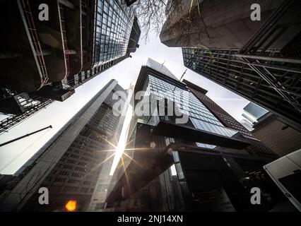 22. Februar 2023, Hessen, Frankfurt/Main: Die Sonne scheint durch die Hochhausschluchten Frankfurts, die dank des Neubaus des Viererprojekts neue Perspektiven eröffnen (l). An diesem Standort werden derzeit vier Türme mit einer Höhe von bis zu 233 Metern errichtet. Die Hauptniederlassung der Commerzbank ist hinten links zu sehen. Foto: Frank Rumpenhorst/dpa Stockfoto