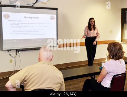 JOINT BASE SAN ANTONO-FORT SAM HOUSTON – (4. August 2022) – Brandy Mason aus San Antonio, ein Praktikant der Naval Medical Research Unit (NAMRU) San Antonio, Sie informierte Wissenschaftler und Forscher der NAMRU San Antonio im Rahmen des Naval Research Enterprise Internship Program (NREIP) im Battlefield Health and Trauma Building über ihre Forschung mit dem Titel „Using Phage Display to identify Snake Venom components in Wundproben“. NREIP bringt Studenten und Universitätsstudenten in Labors des Department of Navy, wo sie im Sommer 10 Wochen lang an echter Marineforschung teilnehmen. NREIP gibt Academica Stockfoto