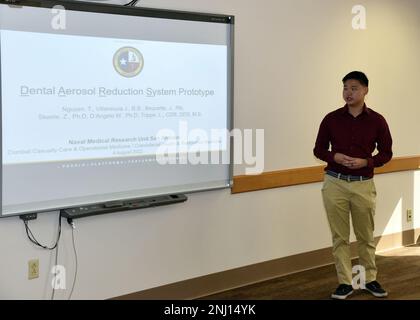 JOINT BASE SAN ANTONO-FORT SAM HOUSTON – (4. August 2022) – Thomas Nguyen aus Orlando, Florida, ein Praktikant der Naval Medical Research Unit (NAMRU) San Antonio, Er informierte Wissenschaftler und Forscher der NAMRU San Antonio im Rahmen des Naval Research Enterprise Internship Program (NREIP) im Battlefield Health and Trauma Building über seine Forschung mit dem Titel „Dental Aerosol Reduction System Prototype“. NREIP bringt Studenten und Universitätsstudenten in Labors des Department of Navy, wo sie im Sommer 10 Wochen lang an echter Marineforschung teilnehmen. NREIP ist akademisch talentierter Stude Stockfoto