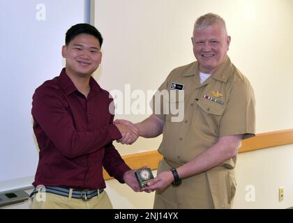 JOINT BASE SAN ANTONO-FORT SAM HOUSTON – (5. August 2022) – Thomas Nguyen aus Orlando, Florida, ein Praktikant der Naval Medical Research Unit (NAMRU) San Antonio, Erhielt eine Kommandomünze vom kommandierenden Offizier Michael Tiller, nachdem er seine Forschung mit dem Titel „Dental Aerosol Reduction System Prototype“ im Battlefield Health and Trauma Building informierte. Nguyen, der an der University of South Florida mit einem Doppelfach in Gesundheitswissenschaften und Maschinenbau studiert, nahm am Naval Research Enterprise Internship Program (NREIP) Teil. NREIP stellt Stude für Hochschul- und Universitätsstudiengänge her Stockfoto