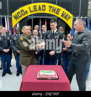 BACHS leitender Befehlshaber Major Marlon Faulds, neu eingestellter Unteroffizier Matthew Murphy und Gastredner William Allen, ehemaliger Kommandofeldwebel Major des Dwight D. Eisenhower Army Medical Center, führen einen traditionellen Tortenschnitt durch, während andere eingeführte Personen die NCO Induction Ceremony des Krankenhauses am 4. August in Fort Campbell, Kentucky, beobachten. Die Zeremonie ist ein altehrwürdiger Armeekonzept, der den Übergang eines einzelnen Soldaten zum Anführer des NCO-Korps markiert. BACH, DHA, MEDCOM, RHCA, Stockfoto