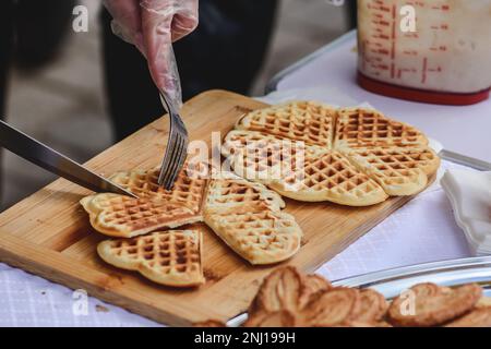 Zubereitung von Waffeln oder Waffeln, Gericht aus gesäuerter Butter oder Teig, das zwischen zwei Tellern gekocht wird, die so gemustert sind, dass sie ein charakteristisches Aussehen erhalten Stockfoto