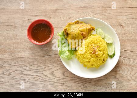 Biryani-Reis, gekocht mit Hühnchen in Curry auf einem Teller mit würziger Chilisauce Stockfoto