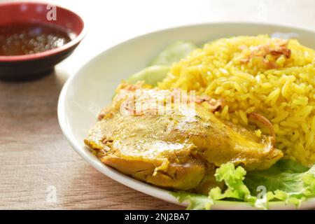 Biryani-Reis, gekocht mit Hühnchen in Curry auf einem Teller mit würziger Chilisauce Stockfoto