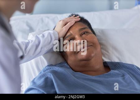 Nahaufnahme einer lächelnden Seniorin, die die Krankenschwester ansieht, während sie auf dem Krankenhausbett liegt Stockfoto