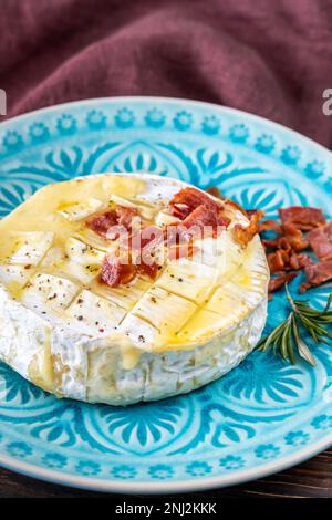 Gebackener Camembert-Käse mit gebratenem Speck Stockfoto