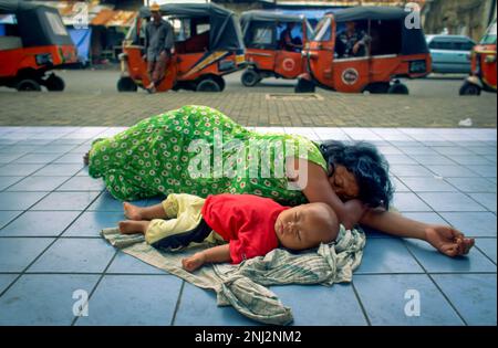 Indonesien, Jakarta. Obdachlose Mutter und Kind, die auf dem Bürgersteig schlafen. Stockfoto