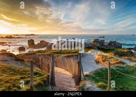 Wunderschöner Sonnenuntergang über dem Strand von Meneham an der Bretagne-Küste Frankreichs Stockfoto