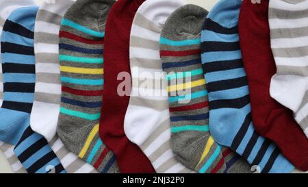 Mehrfarbige Kindersocken mit Streifen als texturaler Hintergrund von Baumwollprodukten, gestreifte Socken als Stoffstruktur Stockfoto