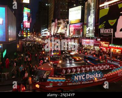 Ein Nachtsicht auf dem Times Square, mit all den Neonlichtern und großen LED-Bildschirmen, die nach Aufmerksamkeit schreien und diesem Ort seine ikonische Atmosphäre und einzigartige Ex verleihen Stockfoto