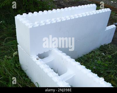 Weiße ICF-Blöcke mit zwei Isolierschichten aus Polystyrol. Isolierter Beton formt den Bau ohne Zement. Stockfoto