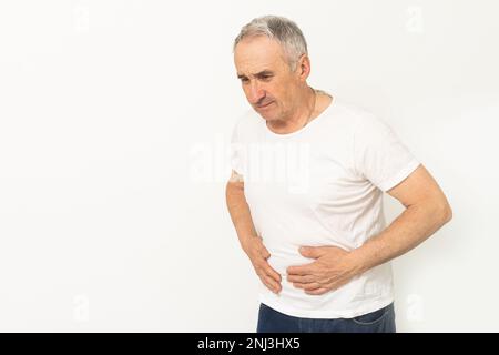 Ältere Männer haben Bauchschmerzen, wenn sie im Haus auf dem Sofa sitzen. Konzeptprobleme des Verdauungstraktes bei älteren Menschen, Gesundheitswesen. Stockfoto