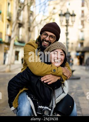 Ein paar Touristen, die im Urlaub auf der Straße der Stadt spazieren gehen - glückliche Freunde, die im Urlaub zusammen lachen - Menschen- und Urlaubskonzept Stockfoto