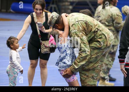 Ein Soldat, der der Alpha Company, 548. Division Sustainment Support Battalion, 10. Mountain Division Sustainment Brigade, 10. Mountain Division zugeteilt wurde, trifft sich mit seiner Familie im Magrath Gym am 5. August 2022 während einer Verlegungszeremonie in Fort Drum, New York. Soldaten kehrten nach einem jahrelangen Einsatz nach Kuwait nach Fort Drum zurück, um logistische Unterstützung zu leisten. Stockfoto