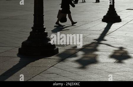 Person, die durch den Innenhof des Hotels De Ville mit Silhouetten der Lampen im französischen Frühling Paris geht Stockfoto