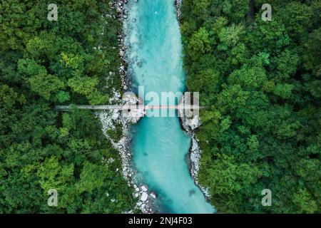 Hängebrücke über einen blauen Fluss in der Mitte des Waldes (Soca-Tal, Slowenien) Stockfoto