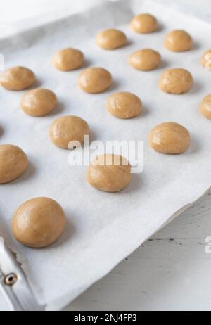 Ungebackene oder rohe Lebkuchen-Kekse auf einem Backblech, isoliert auf weißem Hintergrund Stockfoto