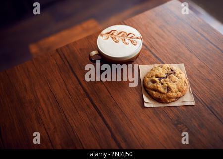 Nahaufnahme Von Dekoriertem Kaffee Und Keks Auf Tisch Im Coffee Shop Stockfoto