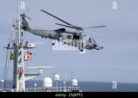 Ein an HDMS Triton angebrachter Royal Danish Navy MH-60R-Hubschrauber fliegt während der Operation Nanook, Nordatlantik, 5. August 2022 über den Mast des Royal Canadian Navy-Schiffes HMCS Goose Bay. Operation Nanook ist eine multinationale Militärübung, die die Fähigkeiten der Vereinigten Staaten und der Partnerländer zur Förderung gemeinsamer maritimer Ziele hervorhebt. Stockfoto