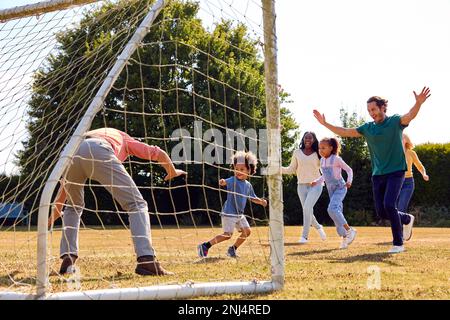 Familie Der Ganzen Generation Zu Hause Im Garten, Die Zusammen Fußball Oder Fußball Spielt Stockfoto