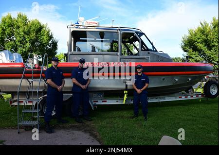 Seemann Young, Chief Campbell und Petty Officer Ortiz-Colon posieren vor dem 29 Meter langen kleinen Boot im Norfolk Tides Stadium, 5. August 2022. Das kleine Boot war eine statische Ausstellung, ein Teil der Nacht der Gezeitenküstenwache. Stockfoto