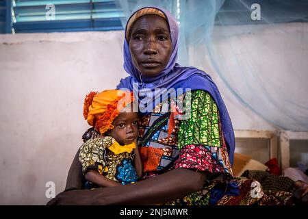 Zouera Saidou liegt im Krankenhaus mit ihrer Enkelin, 2-Jährigen, die 6,4kg kg wiegt – die Hälfte des durchschnittlichen Gewichts eines Kindes in ihrem Alter, das ebenfalls an Unterernährung leidet. Mangelernährung ist eine wiederkehrende Krise in Niger, einem westafrikanischen Binnenland, in dem Klimawandel, Konflikte und eine schnell wachsende Bevölkerung die Herausforderungen in Bezug auf die Versorgung mit Nahrungsmitteln erhöhen. Im Jahr 2022 wurden 4,4 Millionen Nigerianer als dringend auf humanitäre Hilfe angewiesen erklärt. Stockfoto