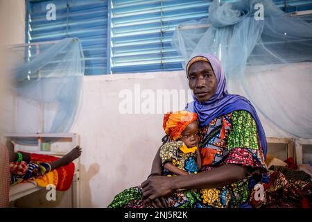 Zouera Saidou liegt im Krankenhaus mit ihrer Enkelin, 2-Jährigen, die 6,4kg kg wiegt – die Hälfte des durchschnittlichen Gewichts eines Kindes in ihrem Alter, das ebenfalls an Unterernährung leidet. Mangelernährung ist eine wiederkehrende Krise in Niger, einem westafrikanischen Binnenland, in dem Klimawandel, Konflikte und eine schnell wachsende Bevölkerung die Herausforderungen in Bezug auf die Versorgung mit Nahrungsmitteln erhöhen. Im Jahr 2022 wurden 4,4 Millionen Nigerianer als dringend auf humanitäre Hilfe angewiesen erklärt. (Foto: Sally Hayden / SOPA Images/Sipa USA) Stockfoto