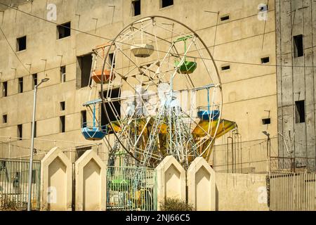 riesenrad vor der Hausmauer in kairo ägypten. Verlorener Ort Stockfoto