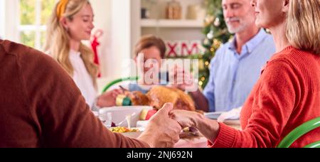 Familie Der Ganzen Generation Feiert Weihnachten Zu Hause Und Betet Vor Dem Gemeinsamen Essen Stockfoto