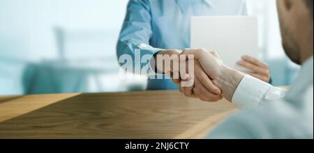 Geschäftsleute geben sich im Büro die Hand. Geschäftsmannspartnerschaft, Vereinbarung und Kooperationskonzept. Banner mit Kopierbereich Stockfoto