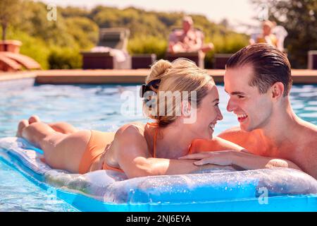 Liebevolles Paar Im Sommerurlaub Entspannen Auf Dem Aufblasbaren Airbed Im Swimmingpool Stockfoto