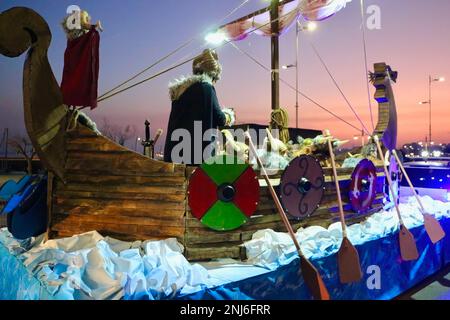 Abendliche Karnevalsparade mit Kindern in einem wikingerboot auf einem Floß in der spanischen Nordküstenstadt Santander Cantabria Spanien am 18. Februar 2023 Stockfoto