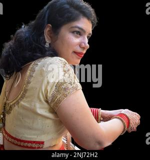 Wunderschöne Frau, die sich als indische Tradition verkleidet hat, mit Henna-Mehndi-Design auf beiden Händen, um das große Festival von Karwa Chauth mit schlichtem weißem B zu feiern Stockfoto