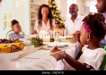 Familie Der Ganzen Generation Feiert Weihnachten Zu Hause Und Betet Vor Dem Gemeinsamen Essen Stockfoto