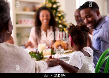 Familie Der Ganzen Generation Feiert Weihnachten Zu Hause Und Betet Vor Dem Gemeinsamen Essen Stockfoto
