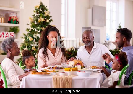 Familie Der Ganzen Generation Feiert Weihnachten Zu Hause Und Betet Vor Dem Gemeinsamen Essen Stockfoto