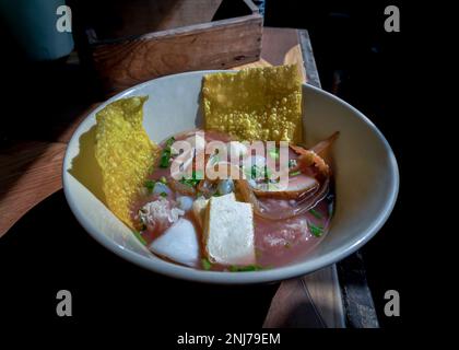 Yentafo Eiernudeln Suppe mit rosa Sauce und Fischbällchen, Garnelen, frischer Tintenfisch, frischer Tintenfisch, eingelegter Tintenfisch, Quallen, Tofu und gebratene Wontons mit Witz Stockfoto